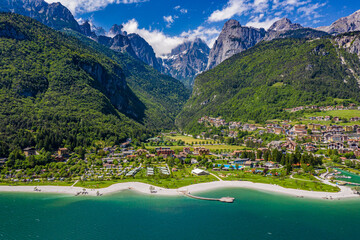 Aerial View of Lago di Molveno in Trentino, Italy, Scenic Alpine Lake with Lush Surroundings and Vibrant Beach
