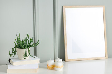 Mockup photo frame on the white wooden cabinet with house plants