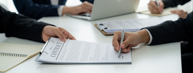 Two business executive in boardroom discuss term and company merging agreement, review corporate...
