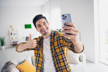 Photo of funky positive man wear checkered shirt showing thumb up tacking selfie modern device...