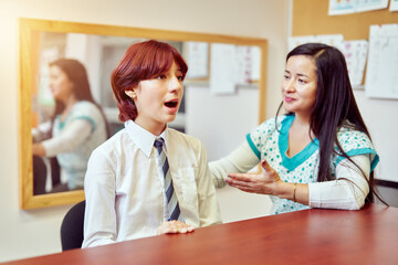 speech therapist working with a high school student at school, language therapy concept 	