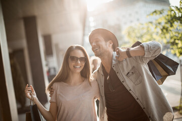 Happy couple shopping and laughing on city street