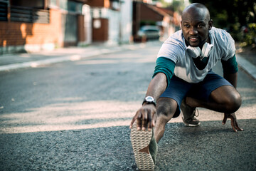 Active young black man stretching on the street