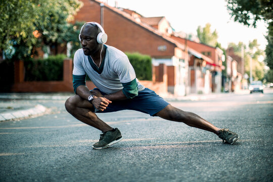 Active young black man stretching on the street