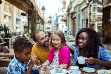 Happy multiethnic family enjoying time at a cafe together