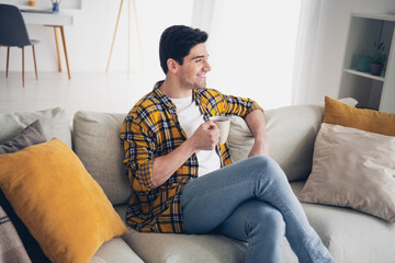 Photo of thoughtful good mood man wear checkered shirt enjoying coffee sitting couch staying home...