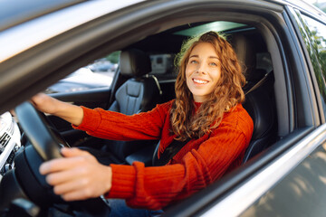 Beautiful Smiling woman driving car, attractive girl sitting in automobile. Young traveler driving....