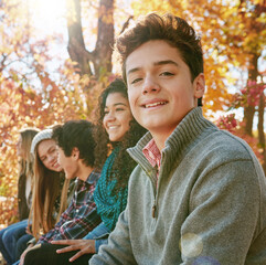 Boy, group and park with relax or teen with casual, trees in nature with smile. Friends, people and young in portrait or happy with diversity in garden for friendship, youth or wellness in Canada