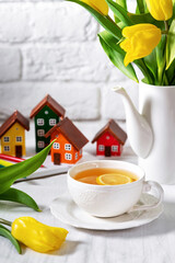 A white cup of tea on the table on a light background