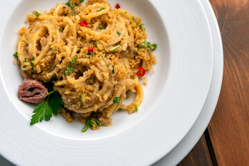 Piatto di deliziosi spaghetti conditi con aglio, olio, peperoncino e pangrattato, cibo italiano 