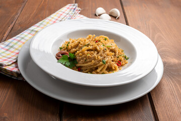 Piatto di deliziosi spaghetti conditi con aglio, olio, peperoncino e pangrattato, cibo italiano 