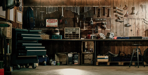 Well-equipped rustic workshop featuring an assortment of tools hanging on a wooden wall, portraying a traditional craftsman environment.