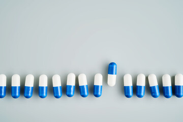 A row of white and blue pills on a blue background.