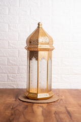 Golden lantern lamp on the table with copy space for greeting text