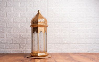 Golden lantern lamp on the table with copy space for greeting text, Eid Mubarak and Ramadan Kareem...