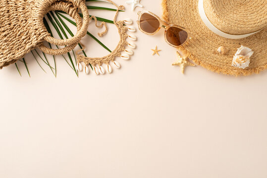 Seaside serenity scene: Top view shot showcasing sunhat, sunglasses, beach bag, island accessories, palm branch, seashells, starfish on pastel beige base, with available area for text or advertising