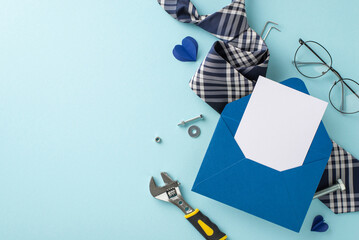 Tribute to Dad's efforts: A top view capture of an open envelope with a personalized postcard, surrounded by work tools, a sophisticated tie, and glasses, against a serene pastel blue backdrop