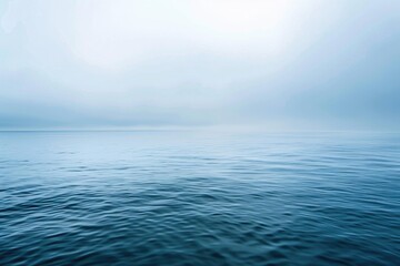 Obraz premium Tranquil Blue Sea. Calm Ocean Landscape with Hazy Background and Cloudy Sky over Horizon