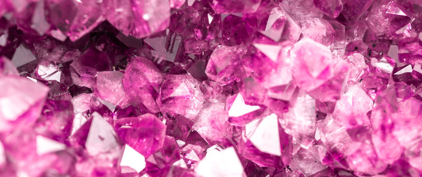 Amethyst pink crystals. Gems. Mineral crystals in the natural environment. Texture of precious and semiprecious stones. Seamless background with copy space colored shiny surface of precious stones.