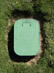 Valve box cover in green grass