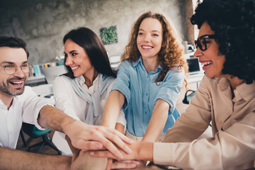 Portrait of group professional corporate workers smile pile stack hands agreement loft interior...