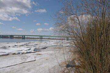 bridge over the river in spring and ice floes near the shore