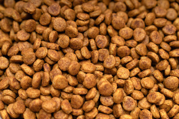 Food for animals background. Dry cat and dog food texture, pattern. Pet meal background close up. Dry food for pet dogs and cats. Dried pet food top view. Granules of good nutrition for dogs and cats.
