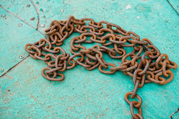 Rusty metal chain on a metal surface aquamarine color. Chain for anchoring. Boat mooring chain