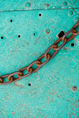 Rusty metal chain on a metal surface aquamarine color. Chain for anchoring. Boat mooring chain
