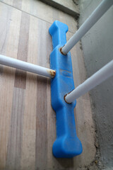 The foot of a clothesline outside the house. white and blue, made of hollow iron and plastic