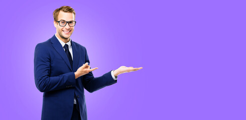 Business man businessman wear eye glasses spectacles, pointing show advertise, hold something, isolated against purple violet wall background with slogan text message empty area. Ad concept image.