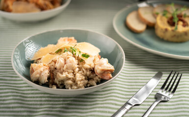Paella spanish dish. Seafood and chicken risotto on blue plate. Rice, shrimps and chicken. Served on table with fork and knife