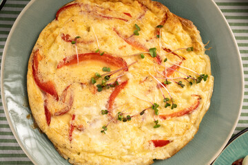 Omelette with red bell pepper on light wooden background. Healthy diet food for breakfast.