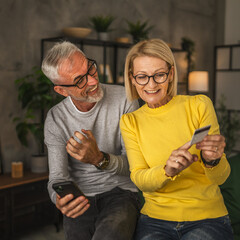 Mature husband and wife are happy after successful online shopping