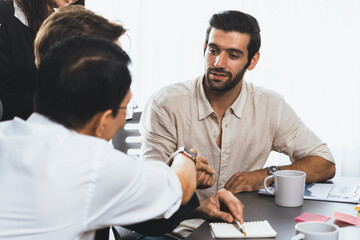 Diverse group of office employee worker shake hand after making agreement on strategic business...