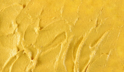 Yellow mustard sauce, spread background and texture, top view	 