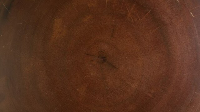 Old Ash tree rings texture close up. Wooden circle stump trunk background from top view. Cross section cut tree trunk with age tree rings wood and counter clockwise rotation.