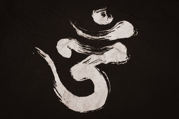 Om word on dark background. Spiritual sign isolated. Sacred Om symbol printed on clothes. Sanskrit...
