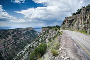 A view of winding road cutting through majestic mountains, showcasing the rugged terrain, A road...