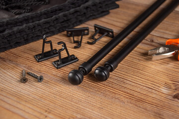 Black accessories for curtains on a wooden table.