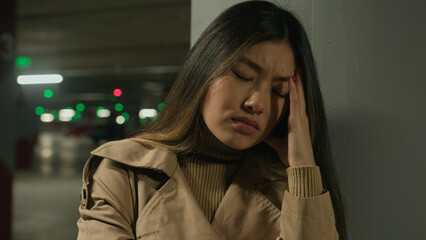 Sick Asian woman suffer headache in parking painful head migraine ache health problem high blood pressure ethnic korean chinese japanese girl feel bad covid symptom unwell illness stress discomfort
