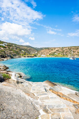 Steps to beach and view of azure sea bay near Chrysopigi monastery, Sifnos island, Greece