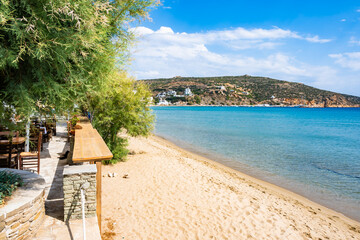 Coastal promenade along azure sea and sandy beach in Platis Gialos village, Sifnos island, Greece