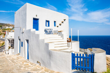 Typical white house with blue entrance gate against blue sea in Kastro village, Sifnos island,...