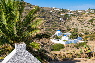 View of church monastery and palm tree in mountain landscape from Kastro village, Sifnos island, Greece