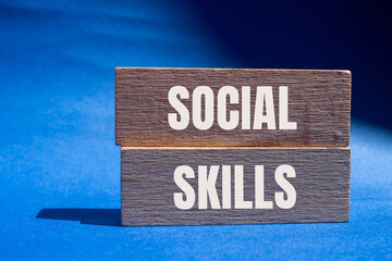 Social skills words written on wooden blocks with blue background. Conceptual social skills symbol....