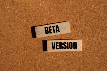 Beta version words written on wooden blocks with brown background. Conceptual beta version symbol....