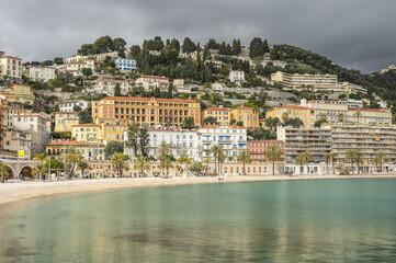 menton, France - 04-01-2024: The beautiful beach of Menton with turquoise water and beautiful colorful houses in the background