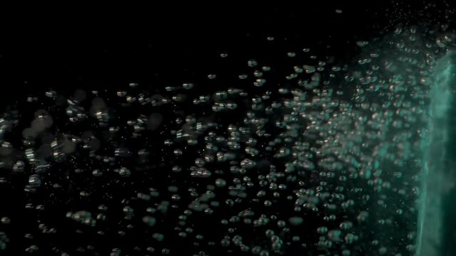 A bath bomb dissolves in water, releasing bubbles and a colorful hue.