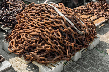 metal rusty chains lay outside on plastic pallets